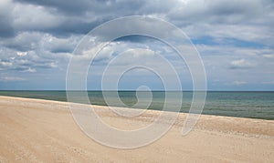 Seascape. Sandy coast and cloudy sky