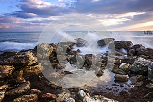 Seascape with scenic clouds over the sea with rocky shore