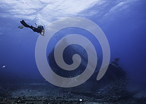 Seascape of a scuba diver approaching a ship wreck