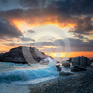 Seascape. Sea Ocean Wave hit the rock at beach, sea water splash up to the sky with sun. Sunset Sundown at Sea. Storm