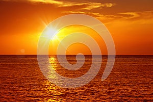 seascape with shiny sea over cloudy sky and sun during sunset in Cozumel, Mexico