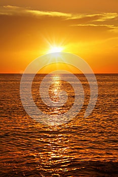 seascape with shiny sea over cloudy sky and sun during sunset in Cozumel, Mexico