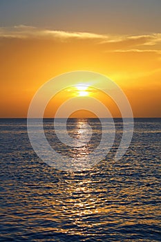 seascape with shiny sea over cloudy sky and sun during sunset in Cozumel, Mexico