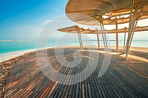 Beach with a wooden walkway and sunshades