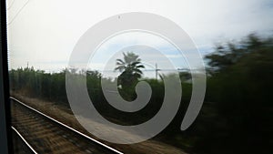 Seascape shown from train moving on railway track, summer vacation, travel