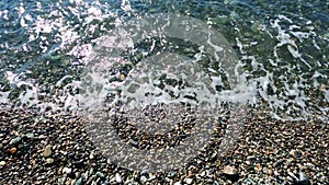 Seascape. small waves are hitting the shore on a pebbly beach.