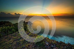 Seascape. Spectacular view from Uluwatu cliff in Bali. Sunset time. Blue hour. Ocean with motion foam waves. Colorful sky. Nature