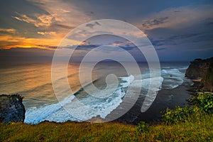 Seascape. Spectacular view from Uluwatu cliff in Bali. Sunset time. Blue hour. Ocean with motion foam waves. Waterscape for