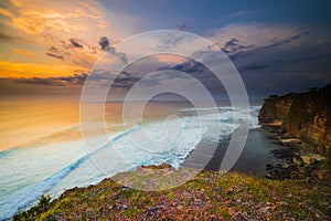 Seascape. Spectacular view from Uluwatu cliff in Bali. Sunset time. Blue hour. Ocean with motion foam waves. Waterscape for