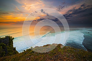 Seascape. Spectacular view from Uluwatu cliff in Bali. Sunset time. Blue hour. Ocean with motion foam waves. Waterscape for