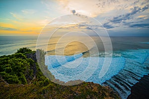 Seascape. Spectacular view from Uluwatu cliff in Bali. Sunset time. Blue hour. Ocean with motion foam waves. Waterscape for