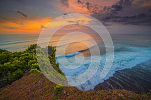 Seascape. Spectacular view from Uluwatu cliff in Bali. Sunset time. Blue hour. Ocean with motion foam waves. Waterscape for