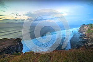 Seascape. Spectacular view from Uluwatu cliff in Bali. Sunset time. Blue hour. Ocean with motion foam waves. Waterscape for