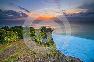 Seascape. Spectacular view from Uluwatu cliff in Bali. Sunset time. Blue hour. Ocean with motion foam waves. Waterscape for