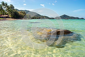 Seascape with stone in clear transparent turquoise sea water on tropical beach