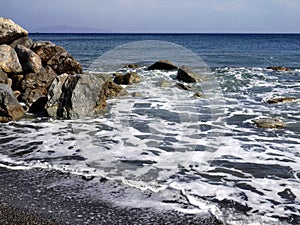 Seascape with stones near Perissa. Santorini island, Greece.