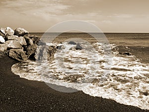 Seascape with stones near Perissa. Santorini island, Greece.