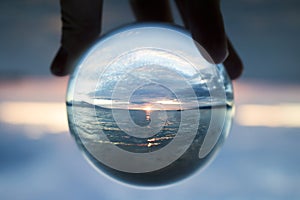 Seascape Sunset Captured in Small Glass Ball with Boat on Horizon