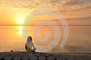 Seascape, sunset, girl sitting on the beach