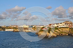 Seascape: sunset lit town on cliffs, blue skies