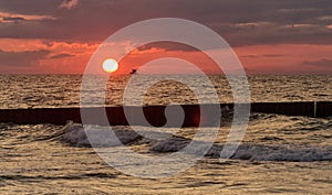 Seascape at sunset in stormy weather. Waves on the sea and dark clouds in the sky. Baltic Sea, Western Pomerania, Poland, Europe