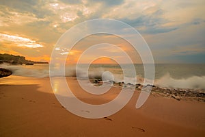 Seascape. Sunset time at the beach. Beach background with footprints in the sand. Tegal Wangi beach, Bali, Indonesia