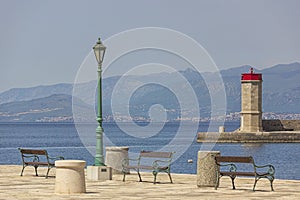 Seascape with three benches and a lighthouse