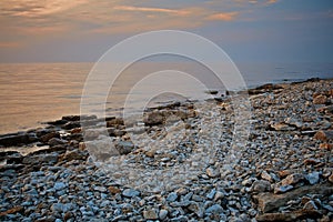 Seascape view. Rocky beach in evening. Pebble shore. Tinted photo