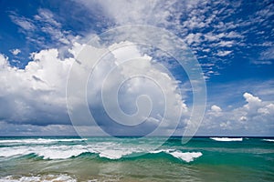 Seascape, waves with white foam on top against the background of blue water