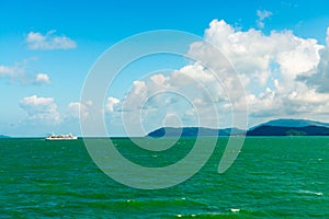 Seascape with white sea ferry and green islands on horizon