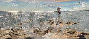 Seascape women relax in  summer hat white  dress sunset pink sky relaxing stay on rock stone at pier beach sea water seagull
