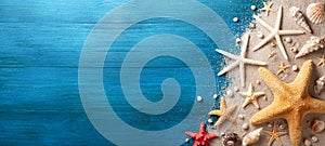 Seashell, starfish and beach sand on blue wooden background. Summer holiday banner. Top view