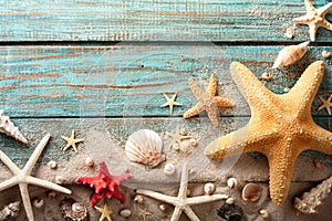 Seashell, starfish and beach sand on blue wooden background. Summer holiday concept. Top view