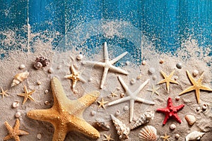 Seashell, starfish and beach sand on blue wooden background. Summer holiday concept. Top view