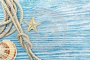 Seashell and starfish, rope with knot on blue wooden background