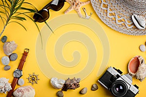 Seashells, accessories and camera on yellow background. Seaside adventures