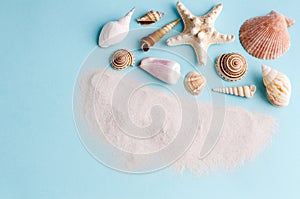 Seashells and clean sand on a blue background with space for text