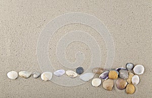 Seashells and stones on sand for relaxation as a background