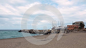 Seashore with breakwater, moored yachts and ships at marina Portorosa
