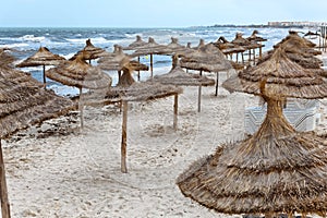 Seashore with parasols from palm leaf on Mediterranean