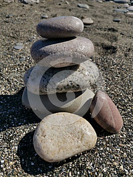 The seashore. Sandy beach. The tower is made of sea pebbles. Balance.
