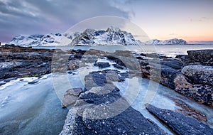 Seashore with stones and ice during sunset. Beautiful natural seascape in the Lofoten islands, Norway.