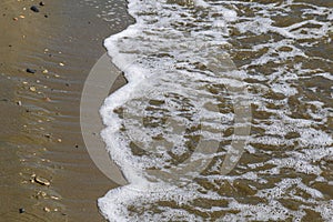 Seashore texture. line water foam over clean sand. Hirozontal