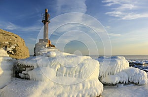Winter sea scape with old lighthouse.