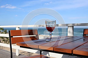 Seaside cafe with sunlit red wine glass