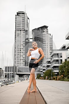 Seaside charisma. Athletic girl pier pose with elegance.