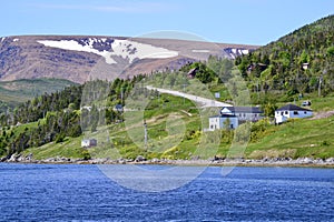 Seaside homes and lush vegetation along Bonne Bay with The Tablelands on the horizon