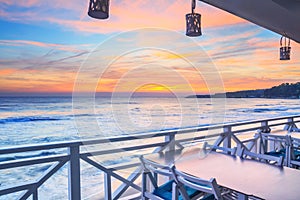 Seaside landscape - the cafe on the embankment with views of the sunrise over the sea