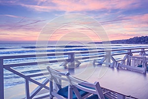 Seaside landscape - the cafe on the embankment with views of the sunrise over the sea