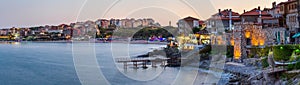 Seaside landscape, panorama, banner - view of the embankment with fortress wall during sunset in the city of Sozopol